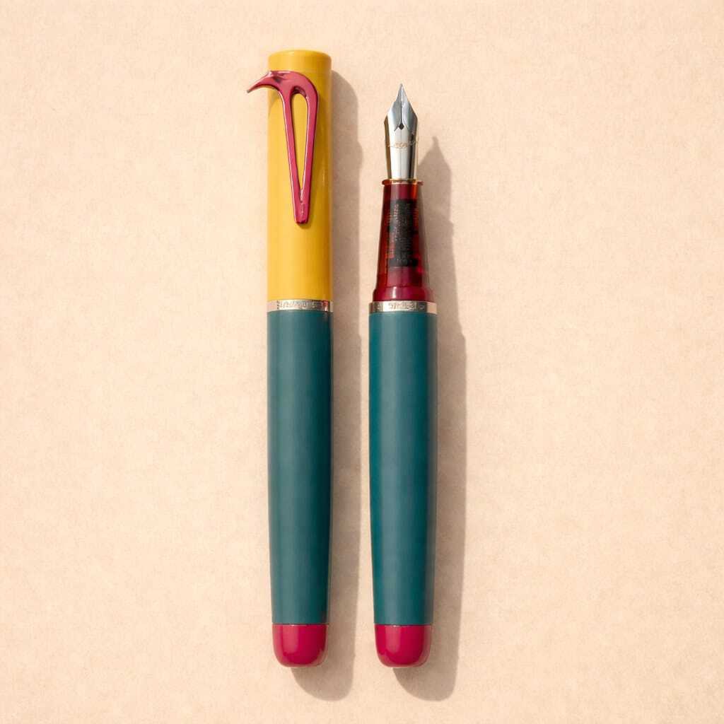 Beaklet Cartagena writing instrument, capped and uncapped, with a yellow cap, muted teal barrel and red beak-shaped clip.