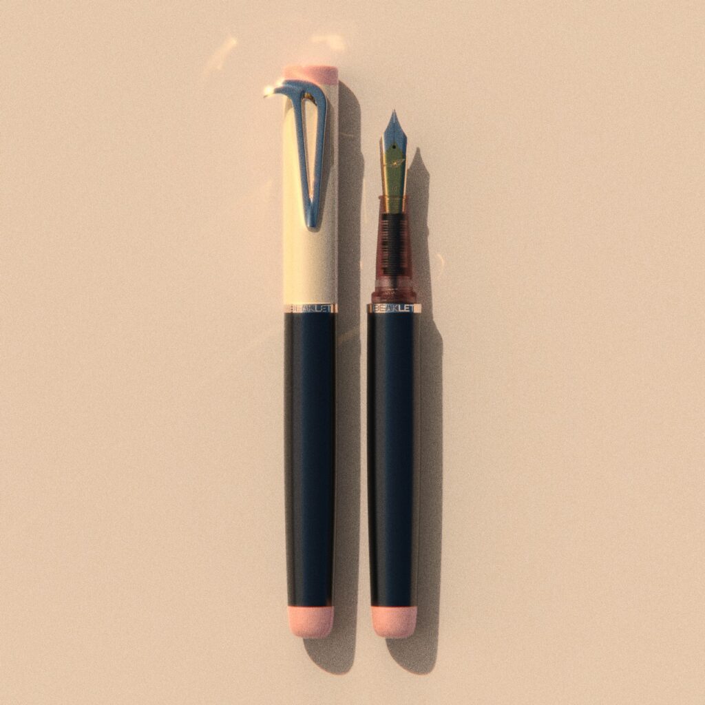 Beaklet Kyoto writing instrument, capped and uncapped, with an ivory cap, dark barrel and soft pink end details.